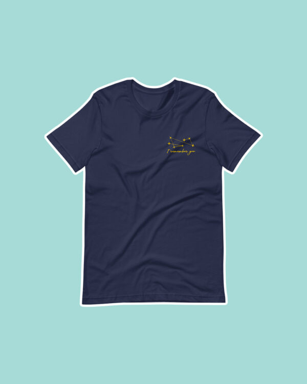 I Remember You Shirt Flat Lay Photo Inspired by The Invisible Life of Addie LaRue on blue background with navy tee shirt and gold embroidery